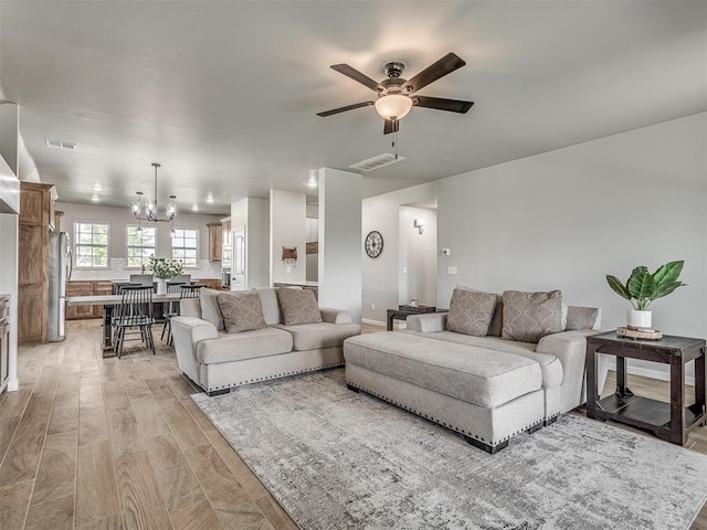 11052 NW 21st St, Yukon, OK 73099 - living room with a chandelier, ceiling fan, and light wood-style floors