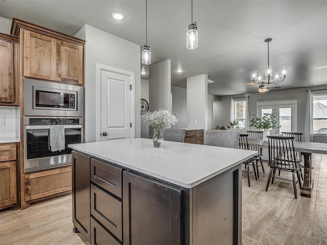 11052 NW 21st St, Yukon, OK 73099 - kitchen featuring stainless steel appliances, a center island, decorative light fixtures, light countertops, and recessed lighting