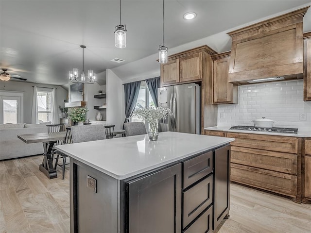 11052 NW 21st St, Yukon, OK 73099 - kitchen with appliances with stainless steel finishes, open floor plan, a ceiling fan, backsplash, and hanging light fixtures