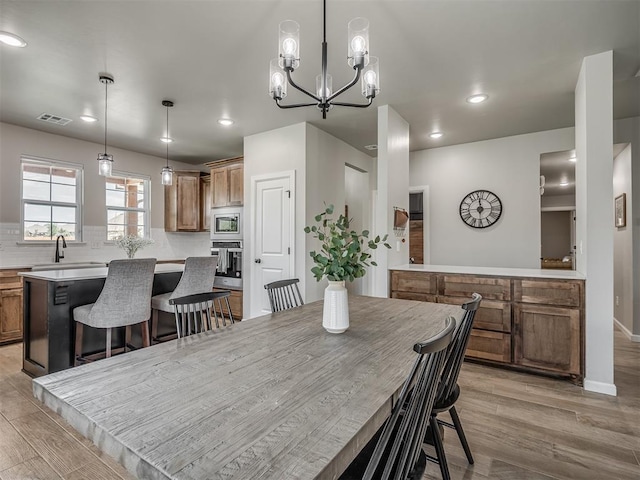 11052 NW 21st St, Yukon, OK 73099 - dining area featuring light wood-type flooring, a chandelier, recessed lighting, and baseboards
