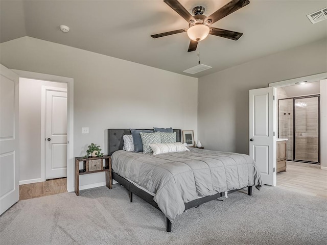 11052 NW 21st St, Yukon, OK 73099 - bedroom with light colored carpet, ceiling fan, baseboards, and connected bathroom