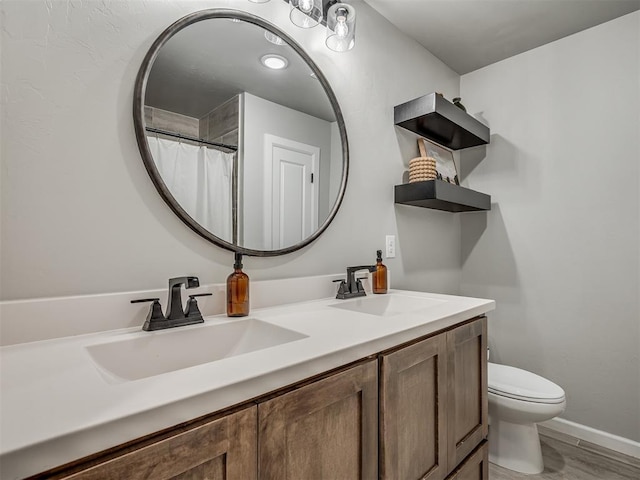 11052 NW 21st St, Yukon, OK 73099 - full bathroom with double vanity, toilet, baseboards, and wood finished floors