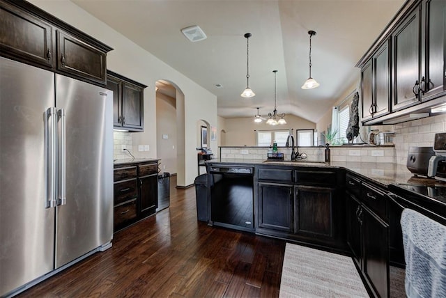 2345 NW 191st Ct, Edmond, OK 73012 - kitchen with black appliances, a sink, a peninsula, arched walkways, and tasteful backsplash