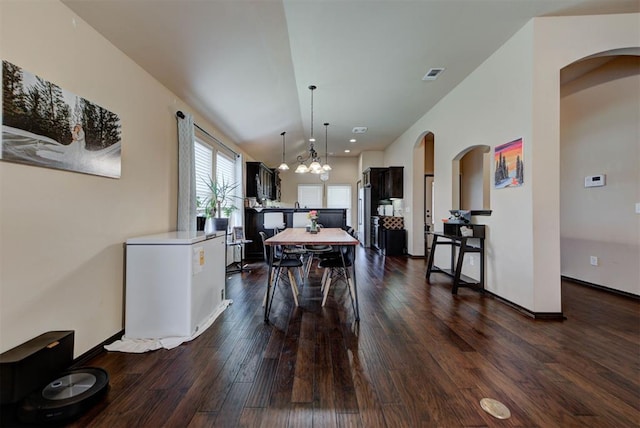 2345 NW 191st Ct, Edmond, OK 73012 - dining room with dark wood-style floors, a chandelier, arched walkways, and baseboards