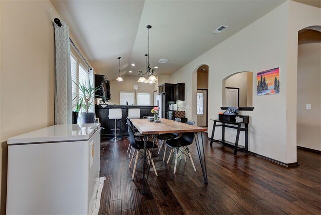 2345 NW 191st Ct, Edmond, OK 73012 - dining space featuring arched walkways, dark wood finished floors, vaulted ceiling, a chandelier, and recessed lighting
