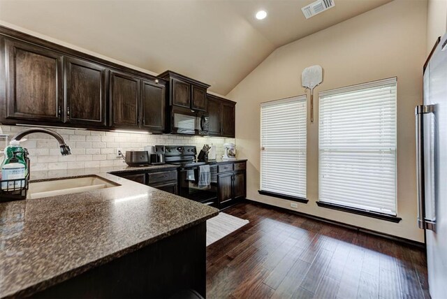 2345 NW 191st Ct, Edmond, OK 73012 - kitchen with a sink, black appliances, vaulted ceiling, dark brown cabinets, and decorative backsplash