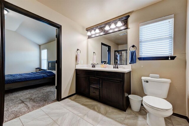 2345 NW 191st Ct, Edmond, OK 73012 - full bathroom with connected bathroom, double vanity, toilet, baseboards, and vaulted ceiling
