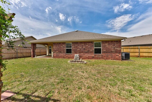 2345 NW 191st Ct, Edmond, OK 73012 - back of property with central AC, brick siding, and a patio area