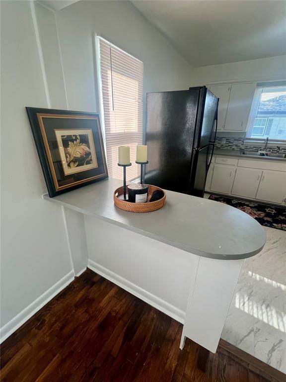 414 N 1st St, Tecumseh, OK 74873 - detailed view of a sink, freestanding refrigerator, wood finished floors, and baseboards