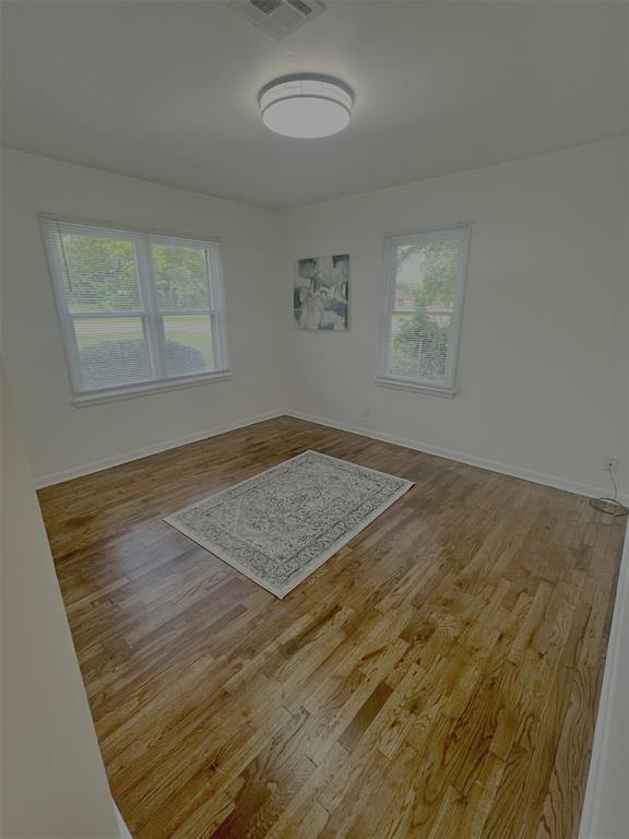 414 N 1st St, Tecumseh, OK 74873 - empty room featuring plenty of natural light, wood finished floors, and baseboards