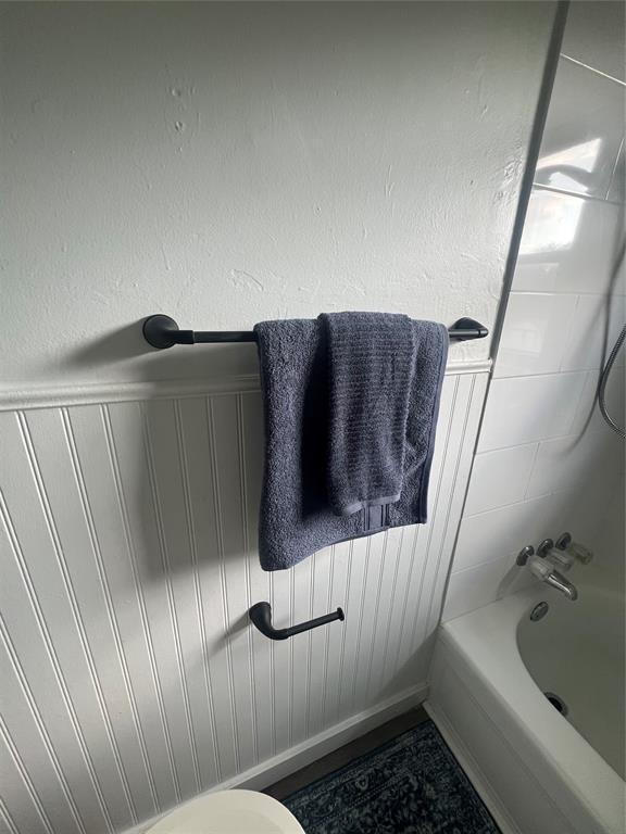 414 N 1st St, Tecumseh, OK 74873 - full bath featuring washtub / shower combination and a wainscoted wall