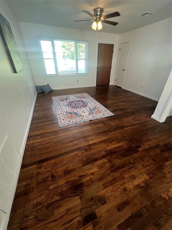 414 N 1st St, Tecumseh, OK 74873 - unfurnished room featuring dark wood-type flooring, baseboards, and ceiling fan