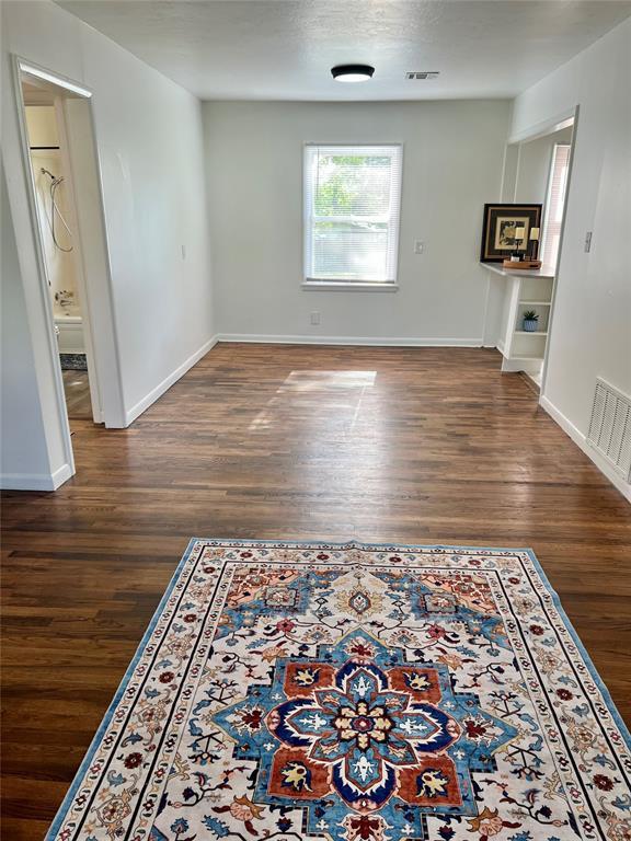 414 N 1st St, Tecumseh, OK 74873 - unfurnished living room with wood finished floors and baseboards