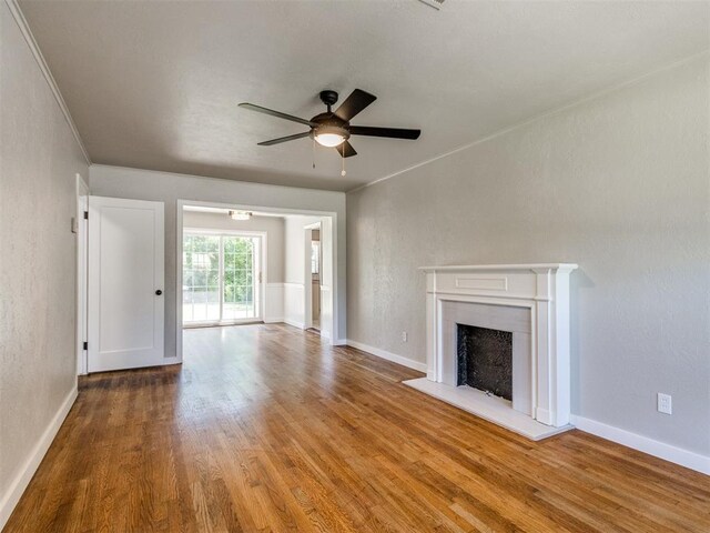 2748 Lancaster Ln, Oklahoma City, OK 73116 - unfurnished living room with wood finished floors, a ceiling fan, a fireplace, ornamental molding, and baseboards