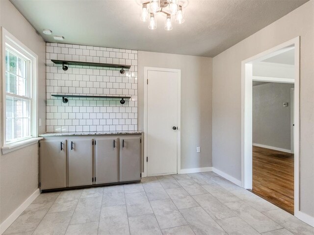 2748 Lancaster Ln, Oklahoma City, OK 73116 - unfurnished room with a chandelier and baseboards