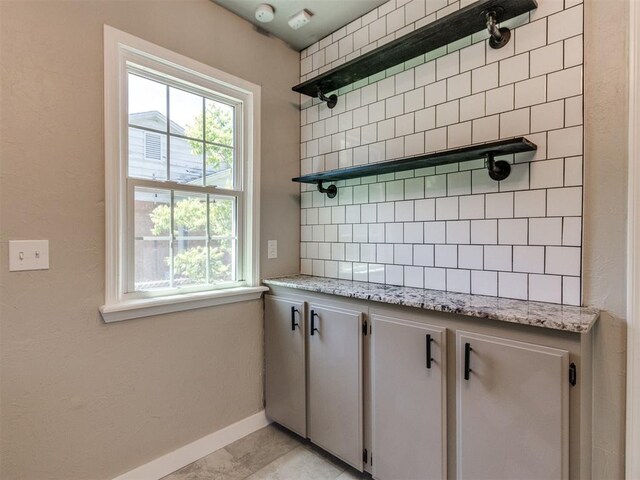 2748 Lancaster Ln, Oklahoma City, OK 73116 - kitchen featuring open shelves, baseboards, light stone countertops, and backsplash