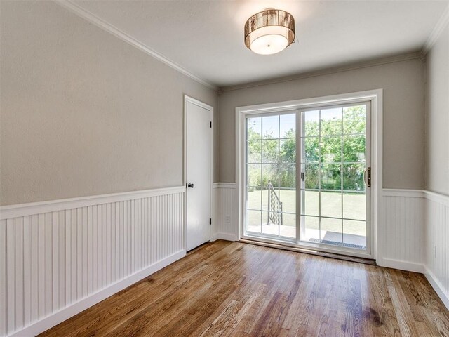 2748 Lancaster Ln, Oklahoma City, OK 73116 - spare room with wood finished floors, a wainscoted wall, and crown molding