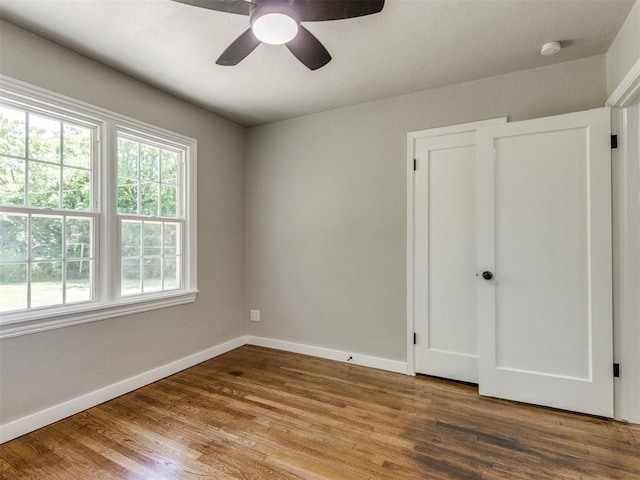 2748 Lancaster Ln, Oklahoma City, OK 73116 - unfurnished bedroom featuring baseboards, wood finished floors, and a ceiling fan