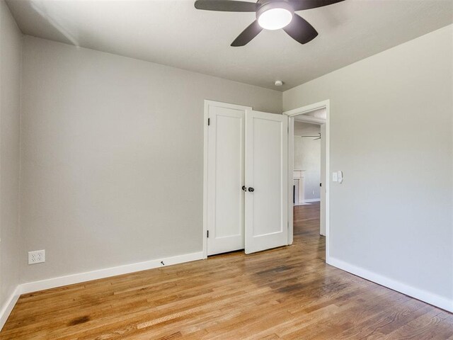 2748 Lancaster Ln, Oklahoma City, OK 73116 - unfurnished bedroom with baseboards, light wood finished floors, and ceiling fan