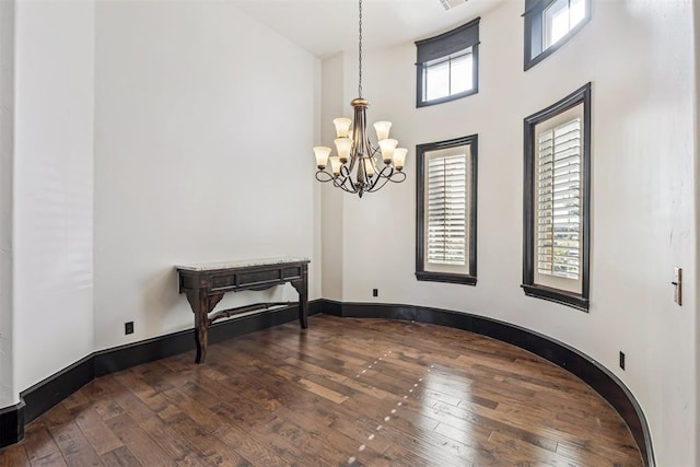 3101 Monica Ln, Moore, OK 73160 - empty room featuring hardwood / wood-style floors, a towering ceiling, and a chandelier