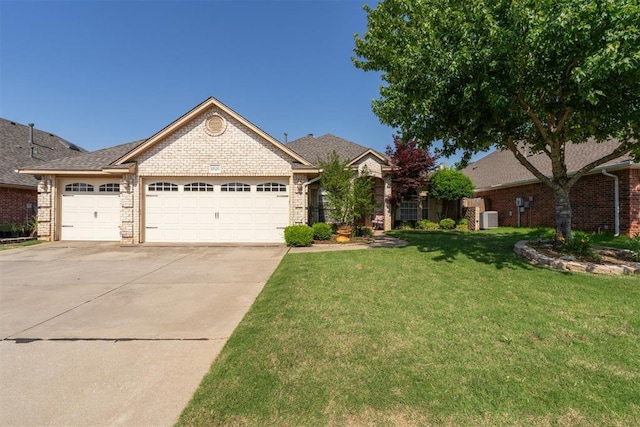 12525 S Youngs Pl, Oklahoma City, OK 73170 - view of front of home with an attached garage, driveway, a front yard, brick siding, and cooling unit