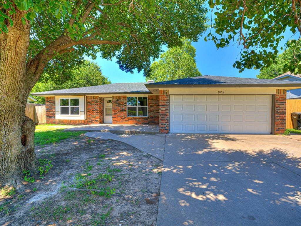 825 N Robinson Ave, Moore, OK 73170 - ranch-style home featuring a garage, concrete driveway, and brick siding