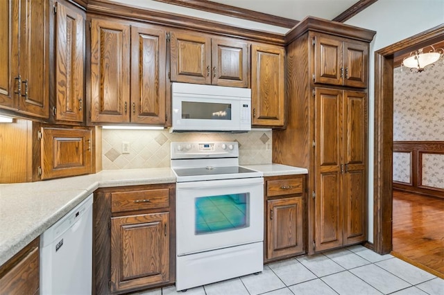 8 Brentwood Pl, Shawnee, OK 74804 - kitchen with white appliances, light countertops, decorative backsplash, brown cabinetry, and wallpapered walls