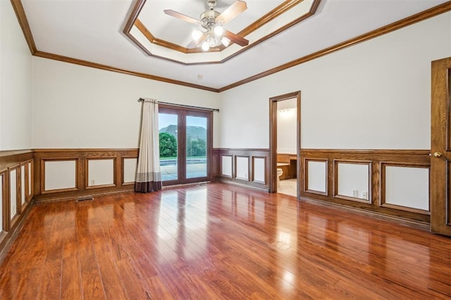 8 Brentwood Pl, Shawnee, OK 74804 - unfurnished room featuring hardwood / wood-style floors, a ceiling fan, a tray ceiling, a wainscoted wall, and crown molding