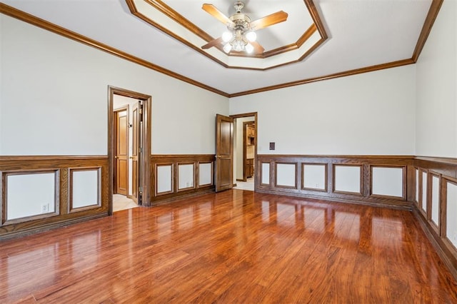 8 Brentwood Pl, Shawnee, OK 74804 - unfurnished room with a raised ceiling, wood finished floors, a ceiling fan, ornamental molding, and wainscoting
