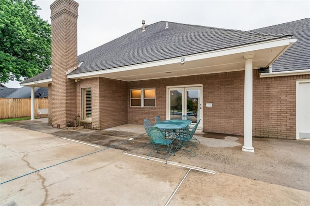 8 Brentwood Pl, Shawnee, OK 74804 - back of house with a shingled roof, a patio area, a chimney, and brick siding