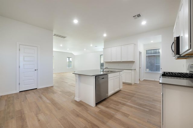 2836 NW 28th St, Yukon, OK 73099 - kitchen with stainless steel dishwasher, a sink, light wood finished floors, open floor plan, and a center island with sink