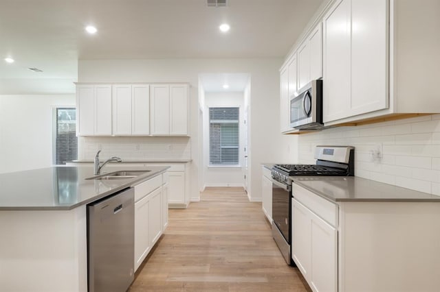 2836 NW 28th St, Yukon, OK 73099 - kitchen with stainless steel appliances, a sink, light wood-style flooring, decorative backsplash, and recessed lighting