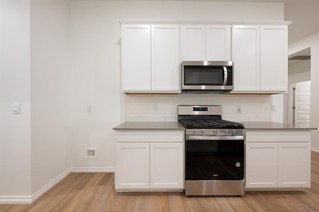 2836 NW 28th St, Yukon, OK 73099 - kitchen featuring appliances with stainless steel finishes, light wood-style floors, tasteful backsplash, white cabinets, and baseboards