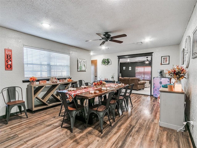 1202 N 8th Ave, Purcell, OK 73080 - dining area with ceiling fan, a textured wall, a textured ceiling, wood finished floors, and plenty of natural light