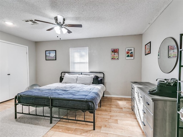 1202 N 8th Ave, Purcell, OK 73080 - bedroom with light wood-type flooring, a textured ceiling, and ceiling fan