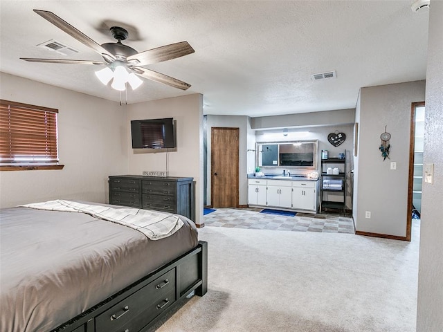 1202 N 8th Ave, Purcell, OK 73080 - bedroom featuring light carpet, ensuite bathroom, baseboards, a sink, and a textured ceiling