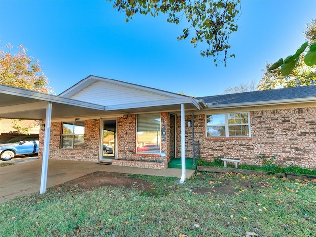 1202 N 8th Ave, Purcell, OK 73080 - view of front of house featuring brick siding and an attached carport