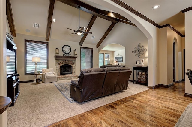2139 Rivanna Way, Edmond, OK 73034 - living room with a ceiling fan, a brick fireplace, arched walkways, wood finished floors, and carpet