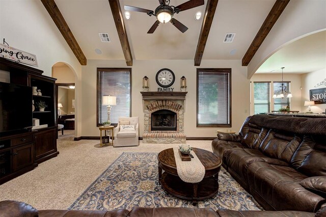 2139 Rivanna Way, Edmond, OK 73034 - living area featuring arched walkways, light carpet, a ceiling fan, a fireplace, and a chandelier