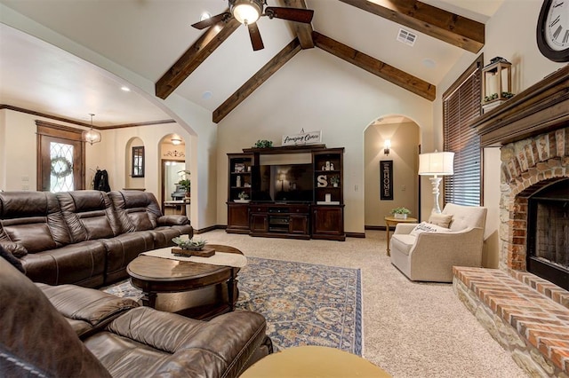 2139 Rivanna Way, Edmond, OK 73034 - carpeted living area with arched walkways, a fireplace, a ceiling fan, beam ceiling, and high vaulted ceiling