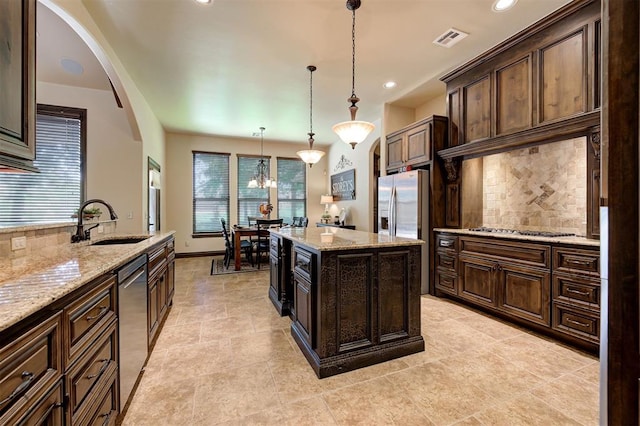 2139 Rivanna Way, Edmond, OK 73034 - kitchen featuring backsplash, appliances with stainless steel finishes, light stone counters, decorative light fixtures, and recessed lighting