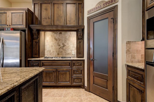 2139 Rivanna Way, Edmond, OK 73034 - kitchen featuring stainless steel appliances, decorative backsplash, light stone counters, and light tile patterned floors