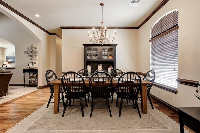 2139 Rivanna Way, Edmond, OK 73034 - dining area with a chandelier, light wood-type flooring, arched walkways, ornamental molding, and recessed lighting