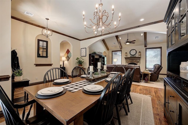 2139 Rivanna Way, Edmond, OK 73034 - dining space featuring arched walkways, a ceiling fan, wood finished floors, a chandelier, and recessed lighting