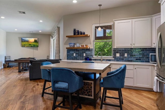 1516 Brook Bank Dr, Jones, OK 73049 - kitchen featuring tasteful backsplash, recessed lighting, white cabinetry, light wood-style flooring, and decorative light fixtures