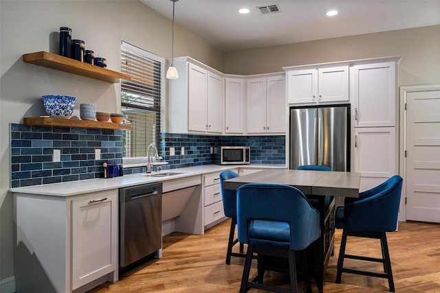 1516 Brook Bank Dr, Jones, OK 73049 - kitchen with stainless steel appliances, white cabinetry, light wood-style flooring, recessed lighting, and tasteful backsplash
