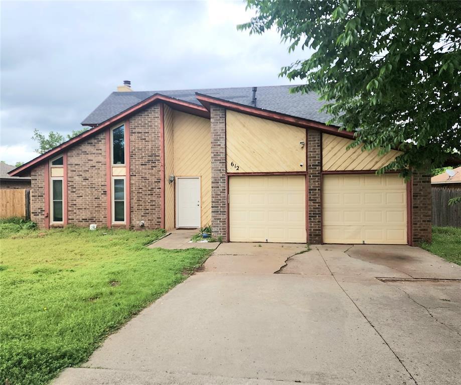 612 Lakeside Cir, Edmond, OK 73012 - view of front facade featuring driveway, a garage, and brick siding