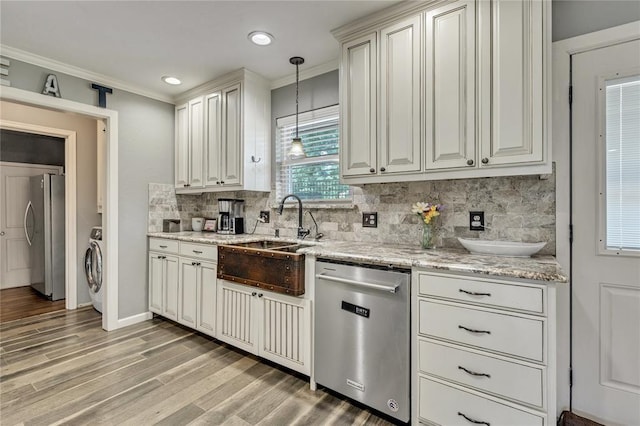 2336 County Road 1222, Blanchard, OK 73010 - kitchen with appliances with stainless steel finishes, a sink, backsplash, washer / clothes dryer, and ornamental molding
