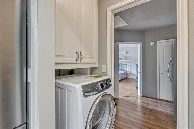 2336 County Road 1222, Blanchard, OK 73010 - laundry room featuring washer / clothes dryer, cabinet space, and wood finished floors