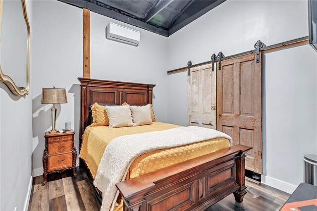 2336 County Road 1222, Blanchard, OK 73010 - bedroom featuring a wall mounted AC, a barn door, dark wood finished floors, and baseboards